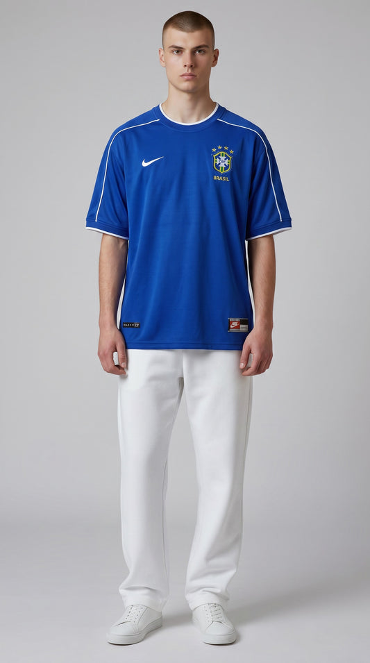 Model wearing a blue My Store 8 Brasil 1998 away soccer jersey with white trim and team crest on a grey background.