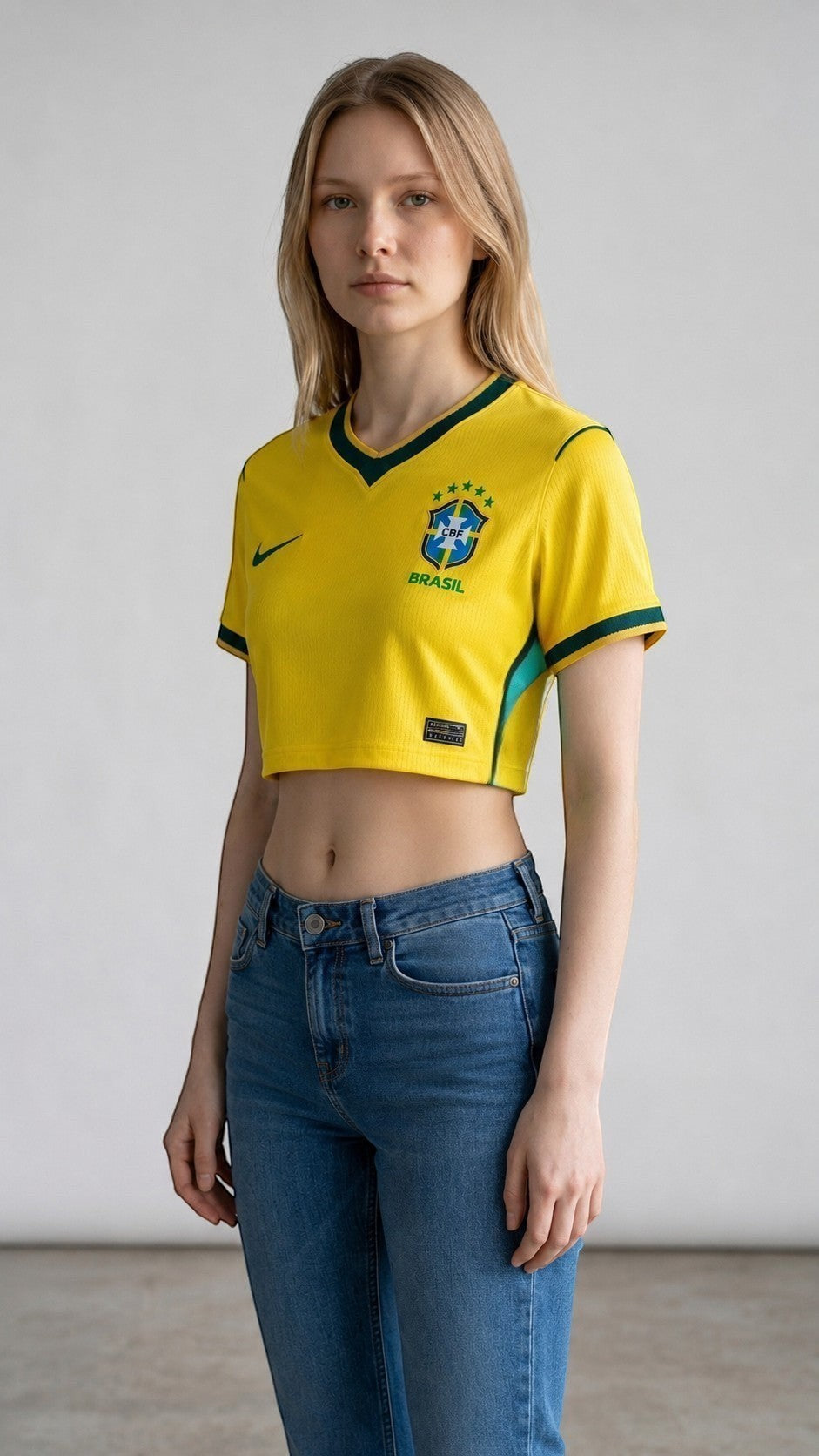 My Store 8 yellow Brazil 2026 women's crop top jersey with green trim and CBF crest worn by a blonde model.